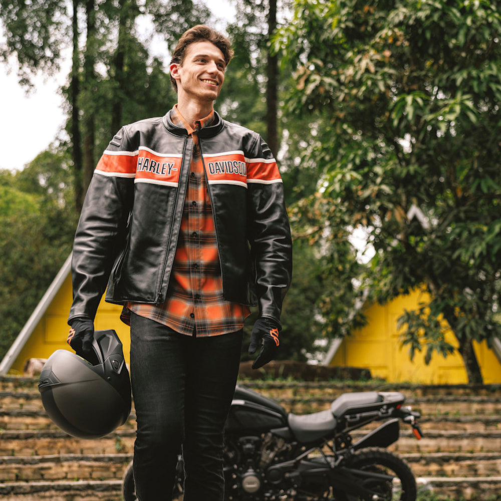 Front view of a man wearing a black Harley-Davidson-style cowhide motorcycle jacket with orange and white panels