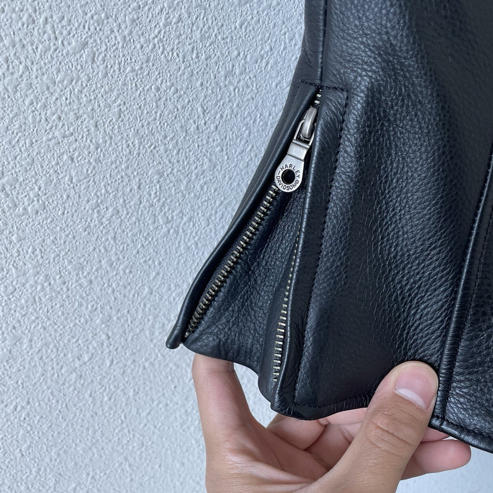 Close-up of side expansion hip zipper on men's black riding vest.
