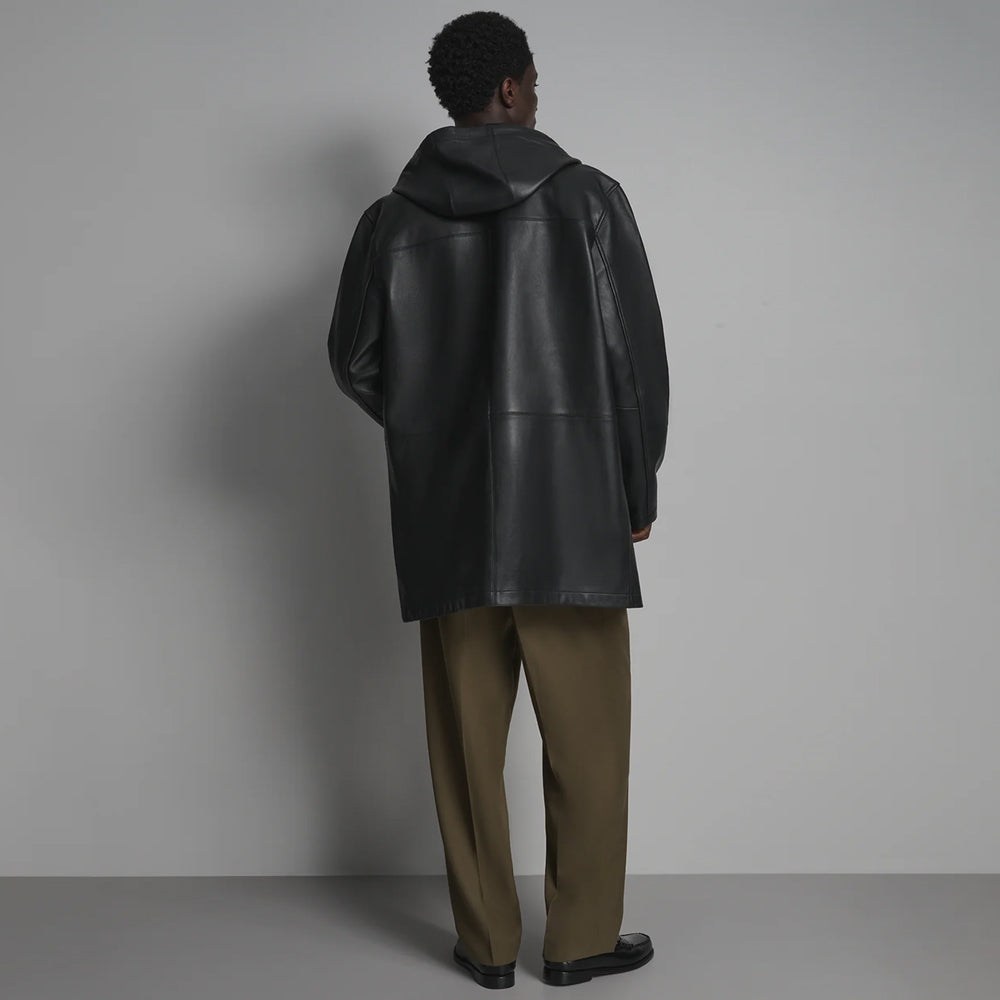 Back view of men’s hooded black leather car coat showing fixed hood, shoulder yoke, lower panel seam and straight longline hem.