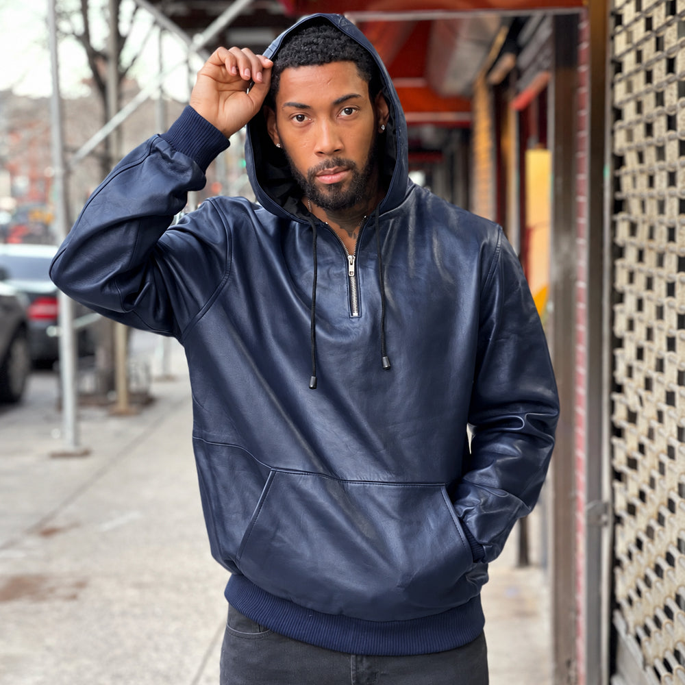 Men’s deep navy leather quarter-zip hoodie worn with the fixed hood raised, showing rib-knit cuffs, waistband and front pouch.