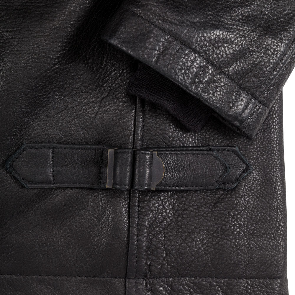 Macro close-up detail of antique metallic side waist cinch buckle and recessed ribbed storm cuff.