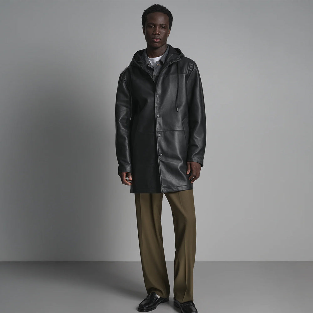 Men’s long black leather hoodie closed with tonal press studs, attached hood, two drawstrings and medium-thigh body.