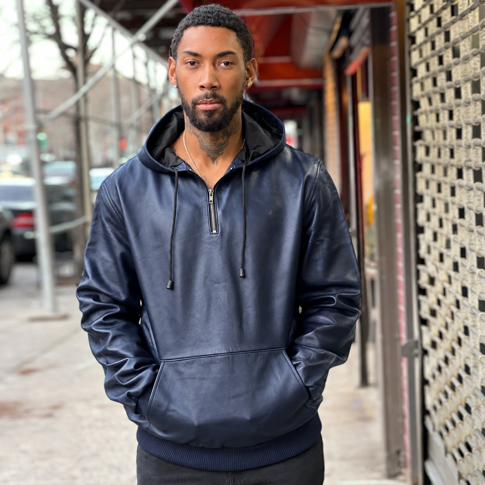 Front view of men’s navy lambskin leather pullover hoodie with fixed drawcord hood, silver-tone quarter zip and kangaroo pocket.
