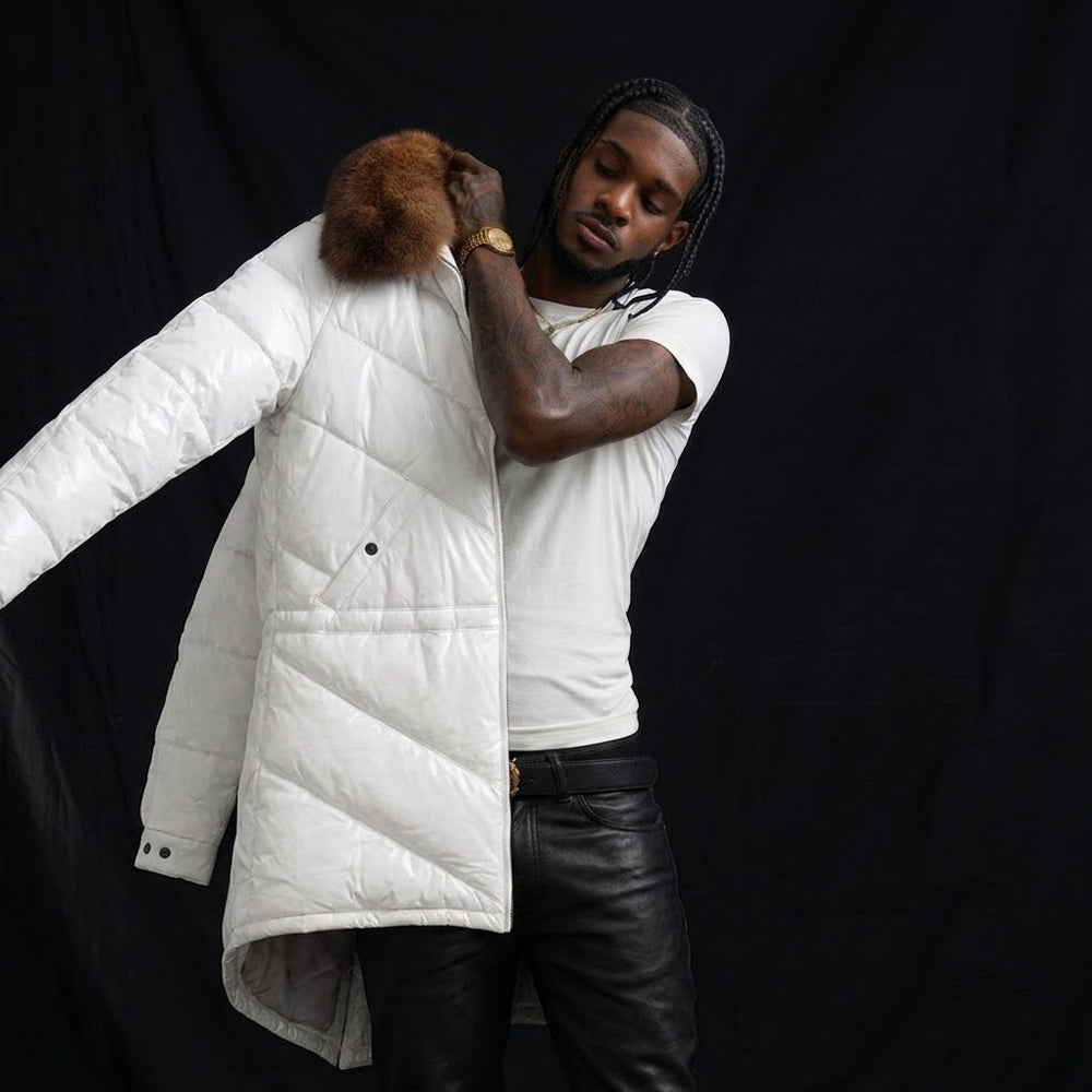 Man wearing off-white leather down coat with brown fur collar against dark backdrop