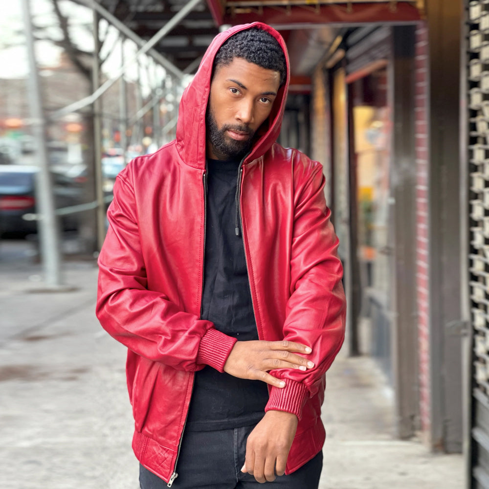 Three-quarter view of men’s red zip-up leather hoodie displaying shaped sleeves, tonal stitching, attached hood and knitted cuffs.