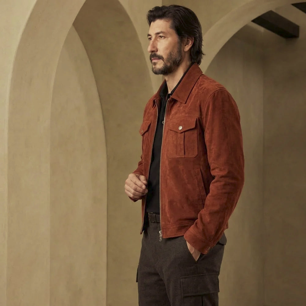 Three-quarter view of men’s reddish-brown lambskin suede jacket showing pointed collar, four-pocket front and regular waist-length fit.