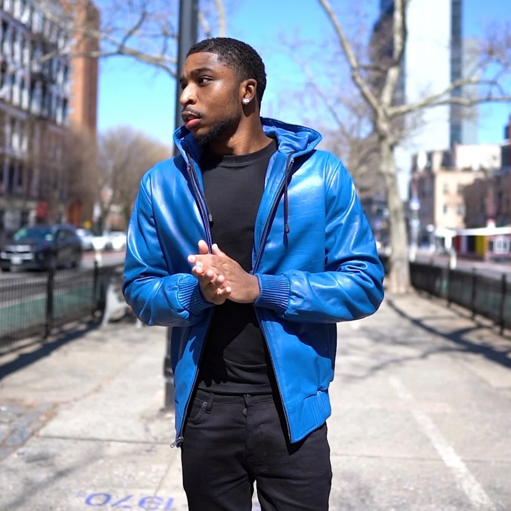 Front lifestyle view of men’s royal blue leather hoodie worn open with fixed drawcord hood, rib-knit cuffs and full silver zipper.