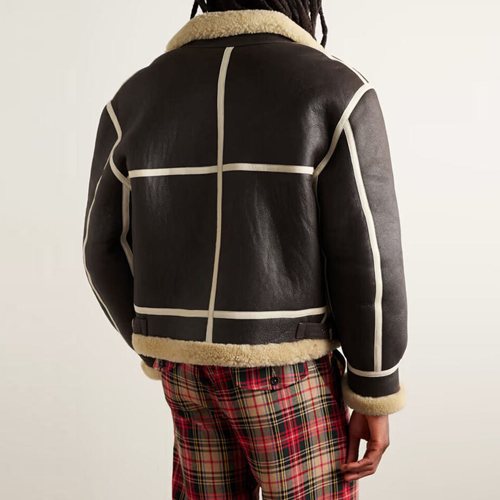 Back view of model wearing men's shearling flight coat displaying 6-panel grid layout framed in cream leather piping