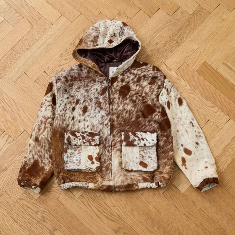 Front flat lay of the men’s speckled cowhide zip jacket showing its lined hood, flap pockets and elastic trims