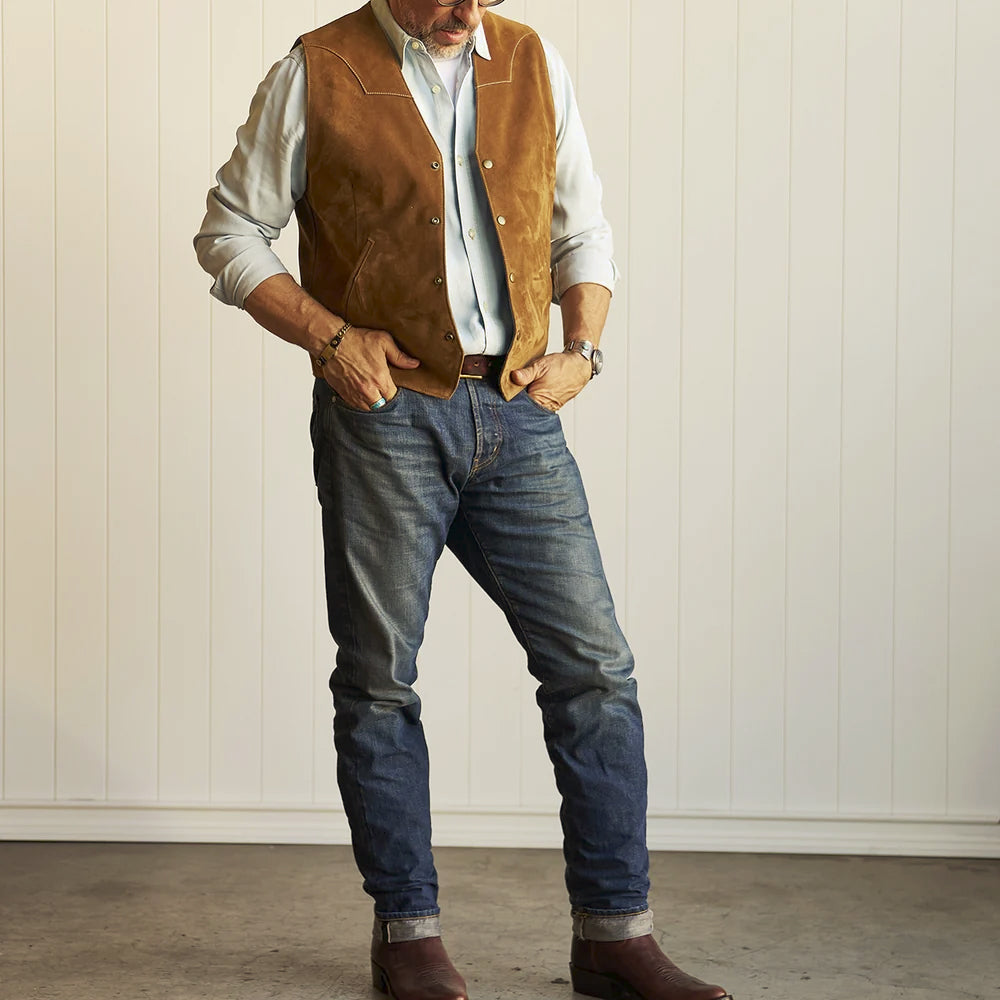 Full-length outfit with men’s tan suede cowboy vest, pale shirt, cuffed denim jeans and brown leather boots