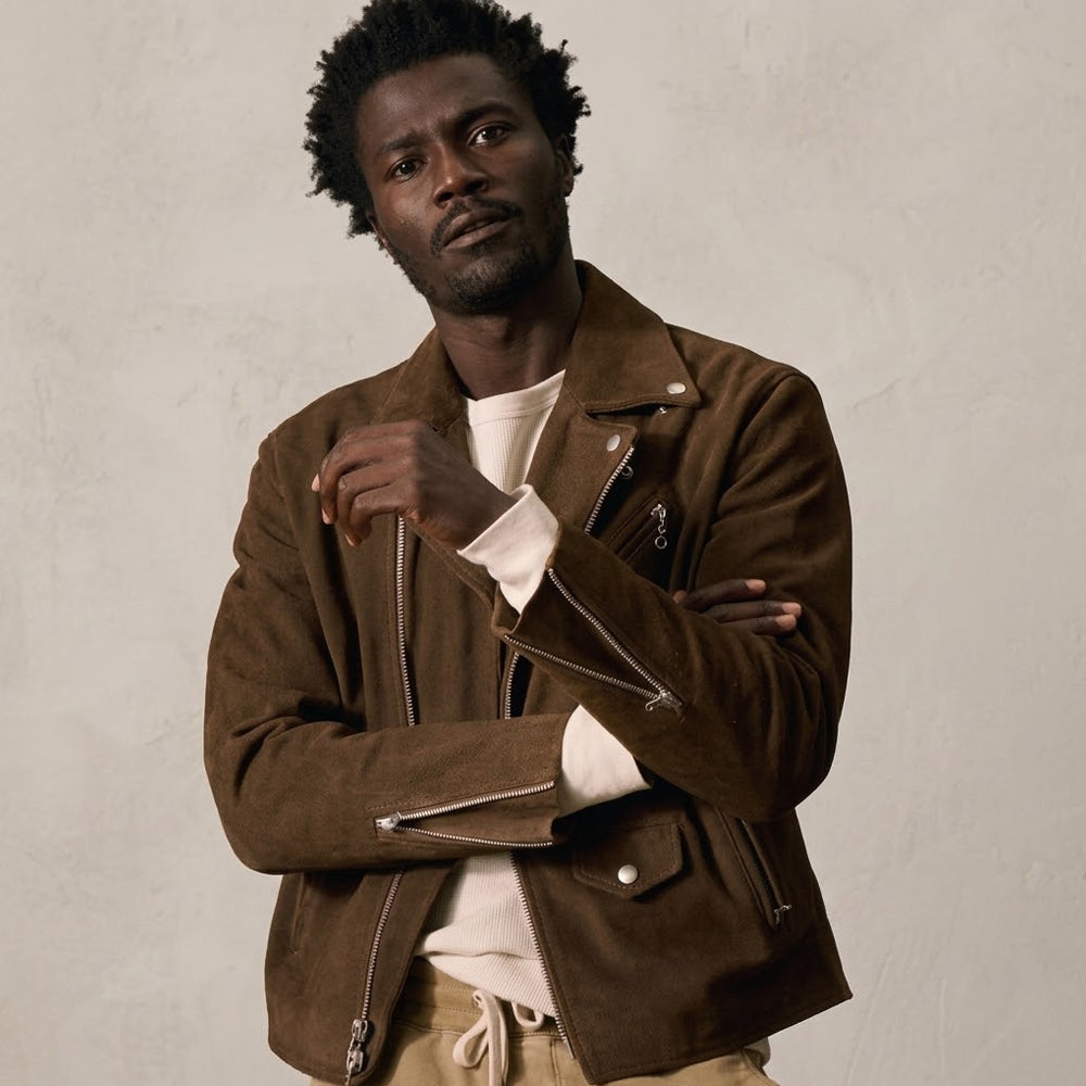 Man wearing a tobacco brown suede biker jacket with asymmetric zip and snap-down lapels.
