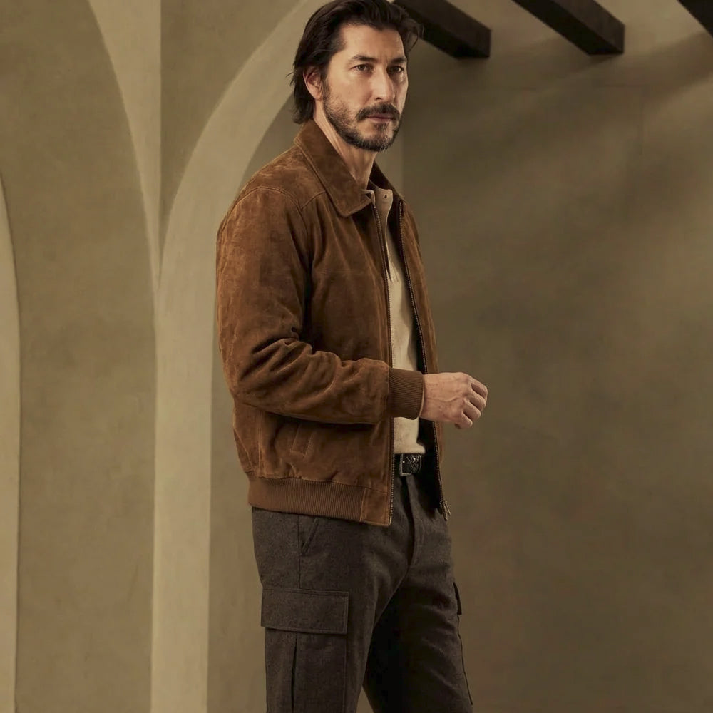 Three-quarter view of men’s tobacco goatskin suede bomber showing regular fit, shaped sleeves and compact ribbed waistband.