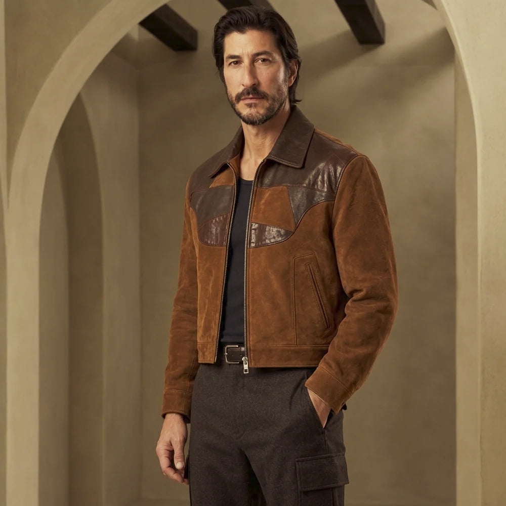 Angled front view of men’s two-tone suede leather jacket with curved color-block chest inlays and antique-brass-tone zipper.
