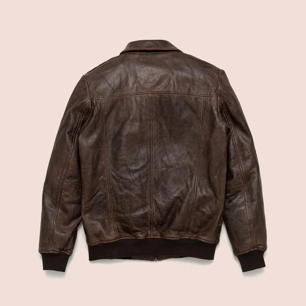 The clean back view of a men's distressed brown leather bomber jacket showing horizontal shoulder seams and ribbed waistband.