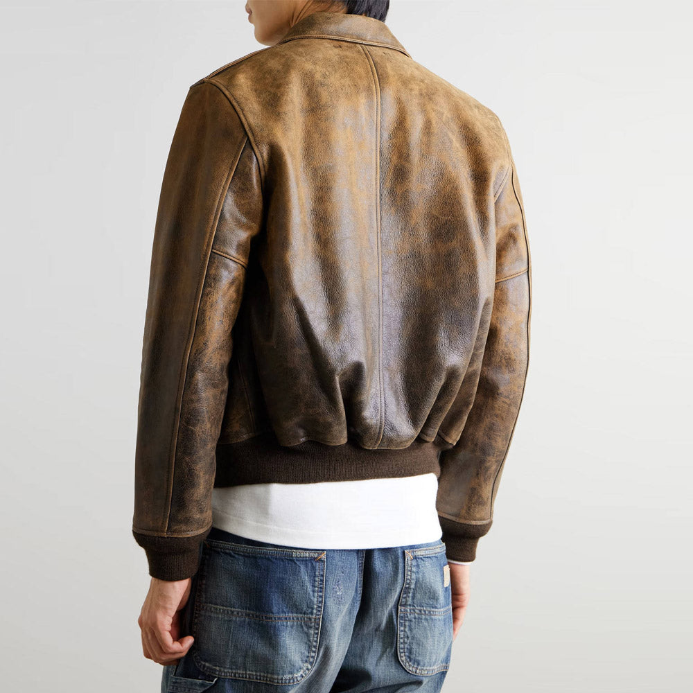 Back view of men's vintage distressed leather bomber jacket showing ribbed cuffs and hem.