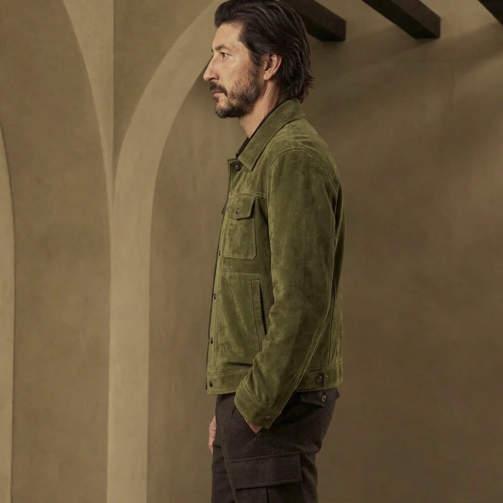 Side profile of men’s waist-length olive suede jacket showing snap cuff, clean sleeve panels and rear hem adjustment tab.