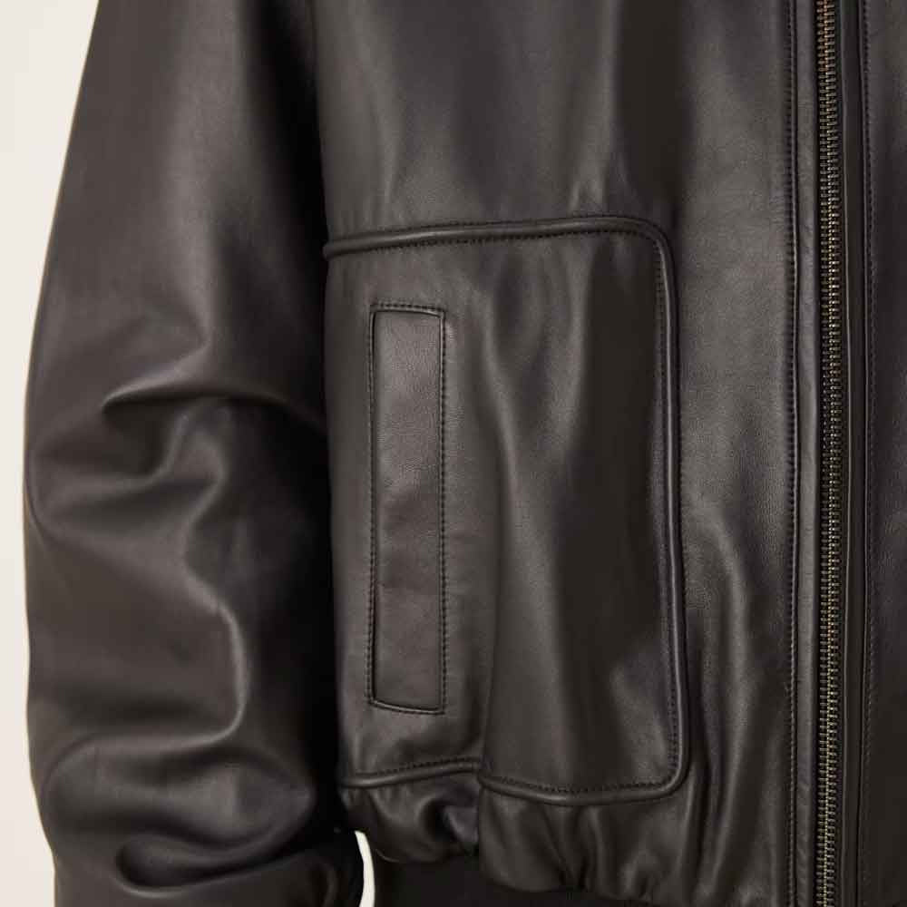 Close view of tall patch pocket with integrated vertical hand opening on Oil Black leather bomber jacket