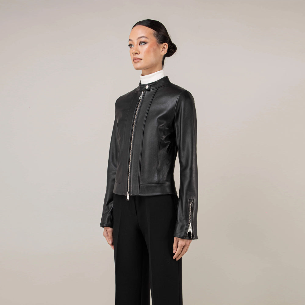 Three-quarter view of oil-black women’s moto jacket with snap-tab stand collar
