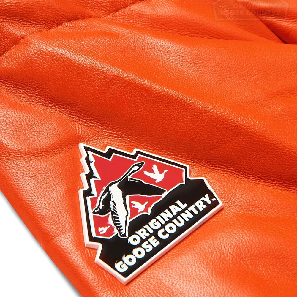 Close-up of Original Goose Country rubber sleeve logo patch on smooth orange lambskin leather