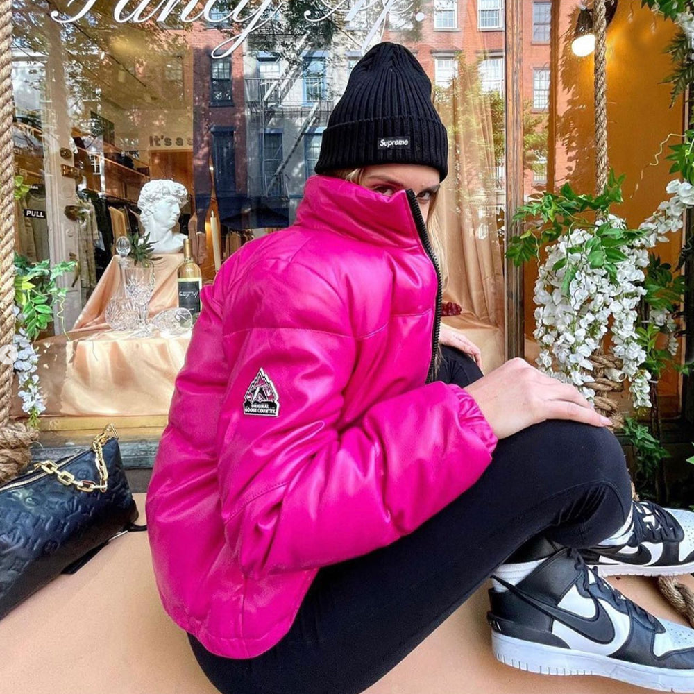 Close lifestyle view of a woman wearing an Original Goose Country pink leather puffer jacket with padded collar and right-sleeve logo patch