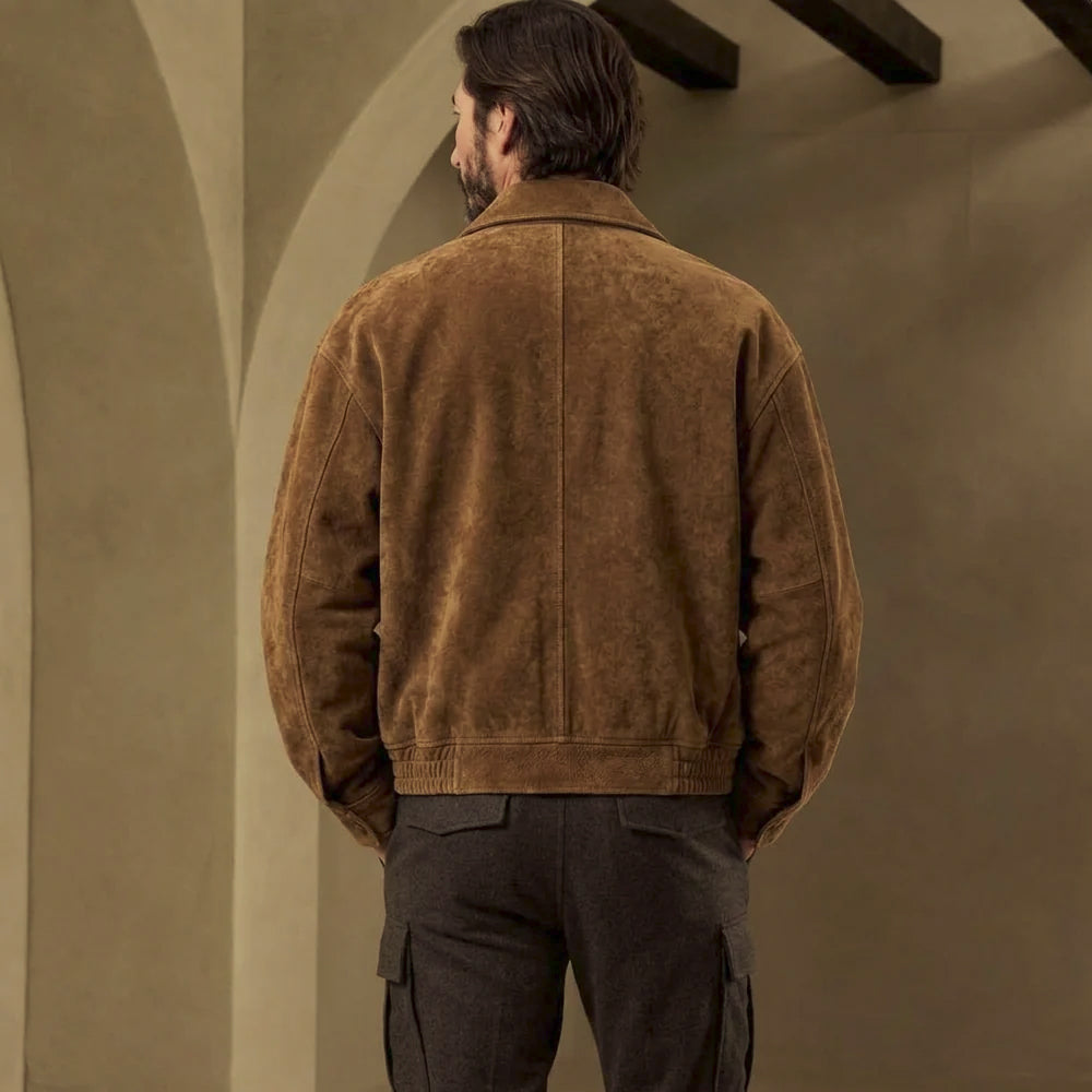 Rear view of oversized tobacco suede trucker jacket showing center-back seam, shoulder paneling, rounded sleeves and clean logo-free finish.