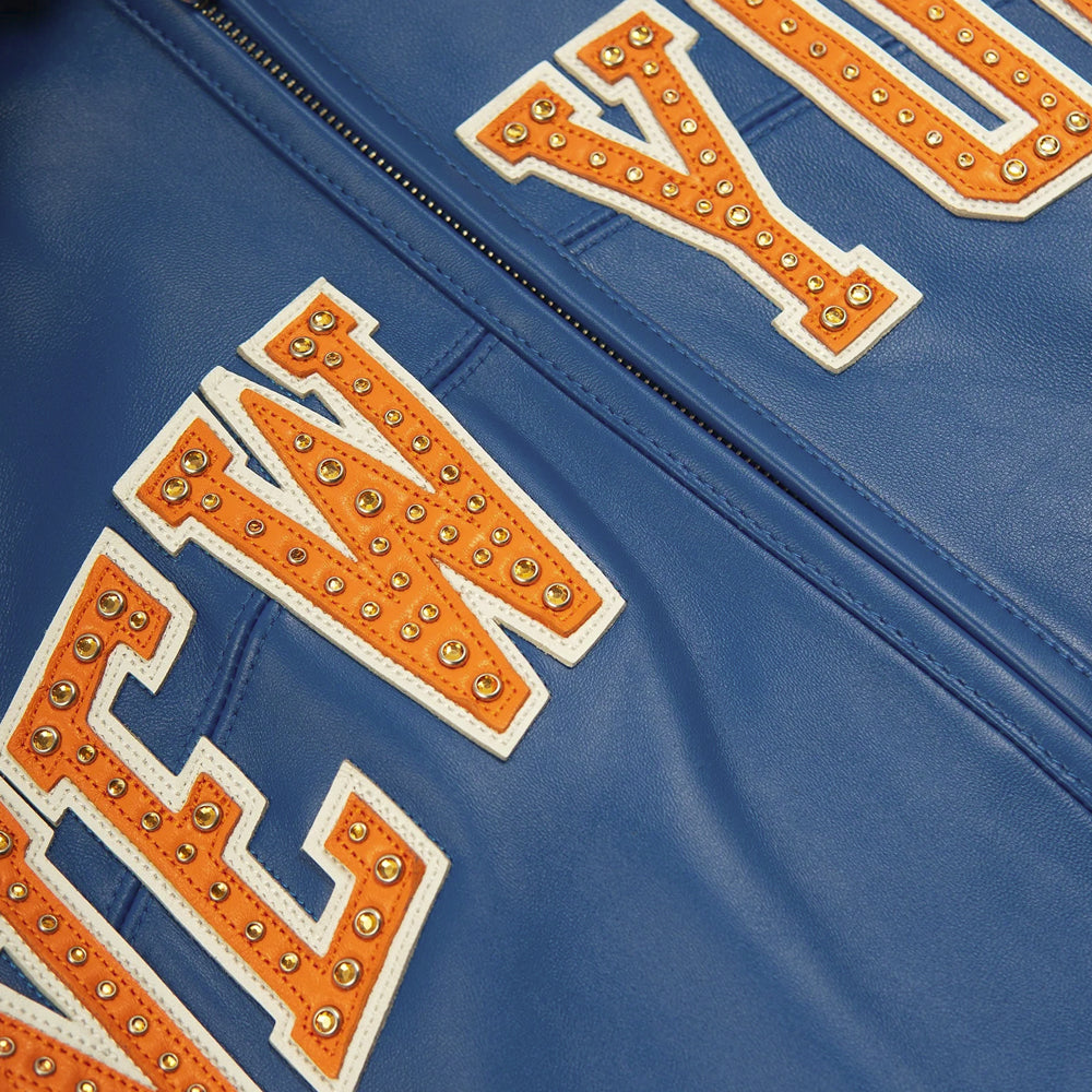 Studded orange and white New York leather lettering beside the blue center zipper