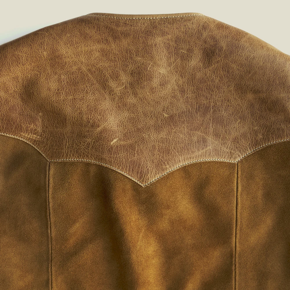 Close-up of the pointed Western back yoke in naturally varied top-grain steerhide above the brushed suede body