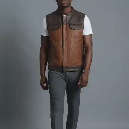 Man modeling a two-tone brown leather biker club vest in a studio