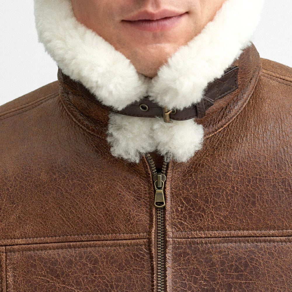 Close up view of white fur collar closed tightly around neck with dark brown leather throat strap