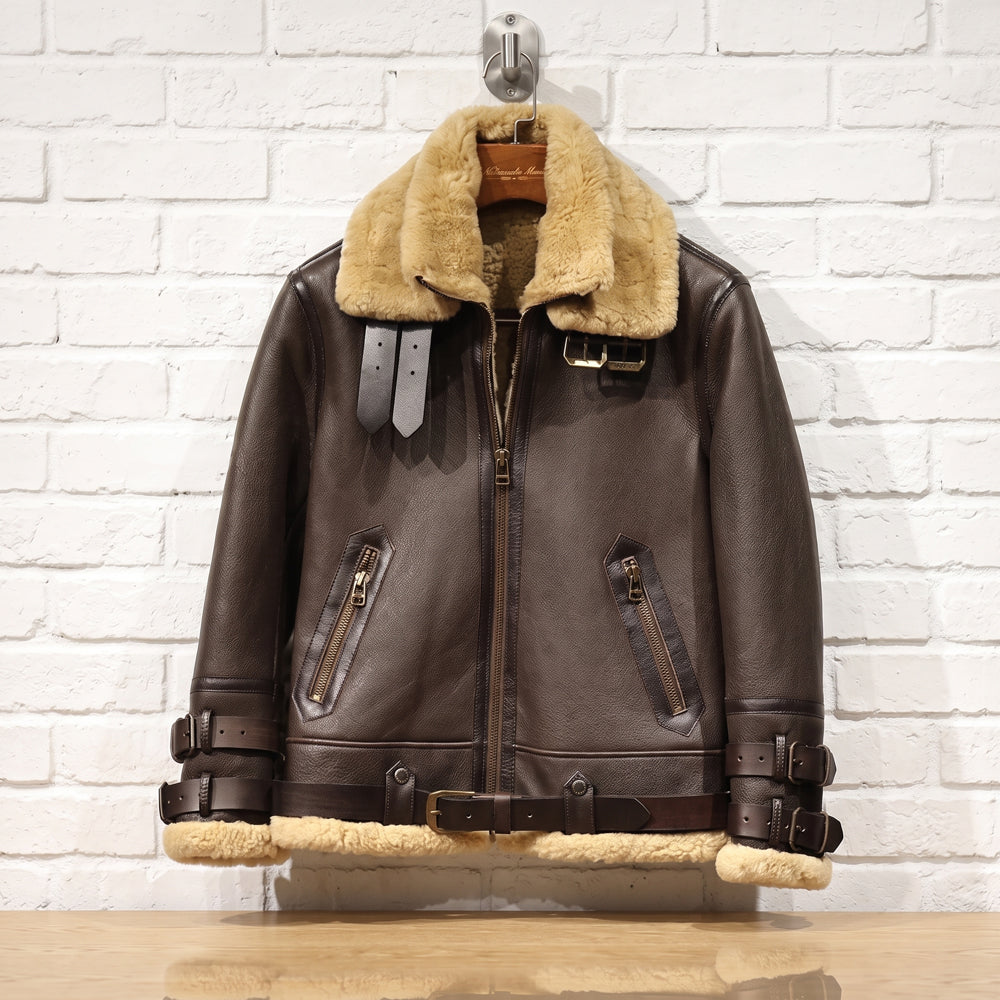 Flat studio view of RAF B3 shearling flying jacket on hanger displaying full waist belt and diagonal zippered pockets