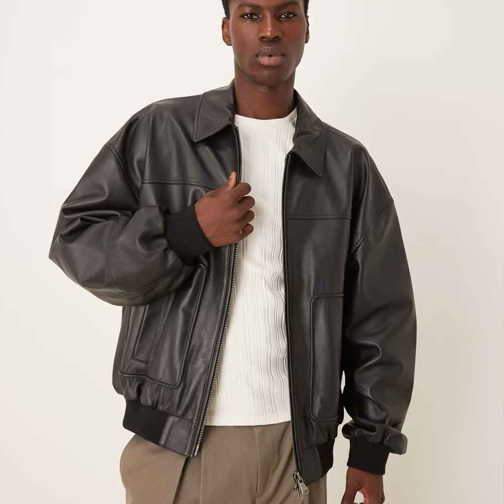 Front three-quarter view of men’s relaxed Oil Black leather bomber showing wide chest, point collar and gathered cuffs