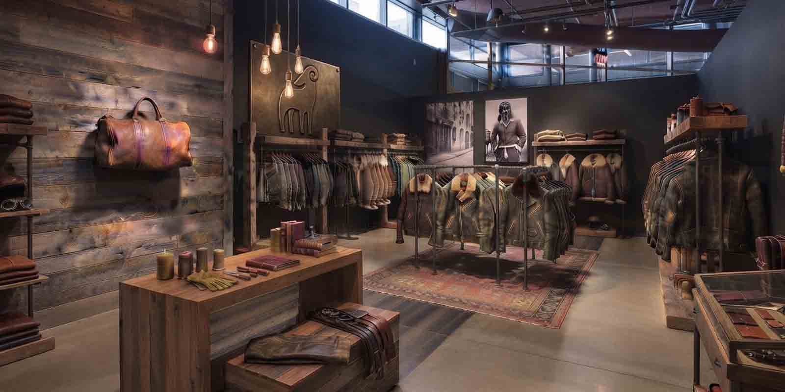 Inside view of the Sheepskin Leathers store featuring a curated collection of premium aged leather and shearling jackets on industrial display racks, with a leather duffel bag and accessories.