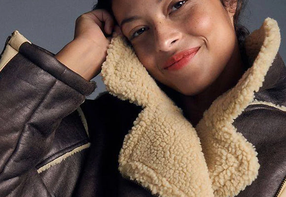 Close-up of genuine sheepskin leather jacket with natural shearling lining collar - real hide construction