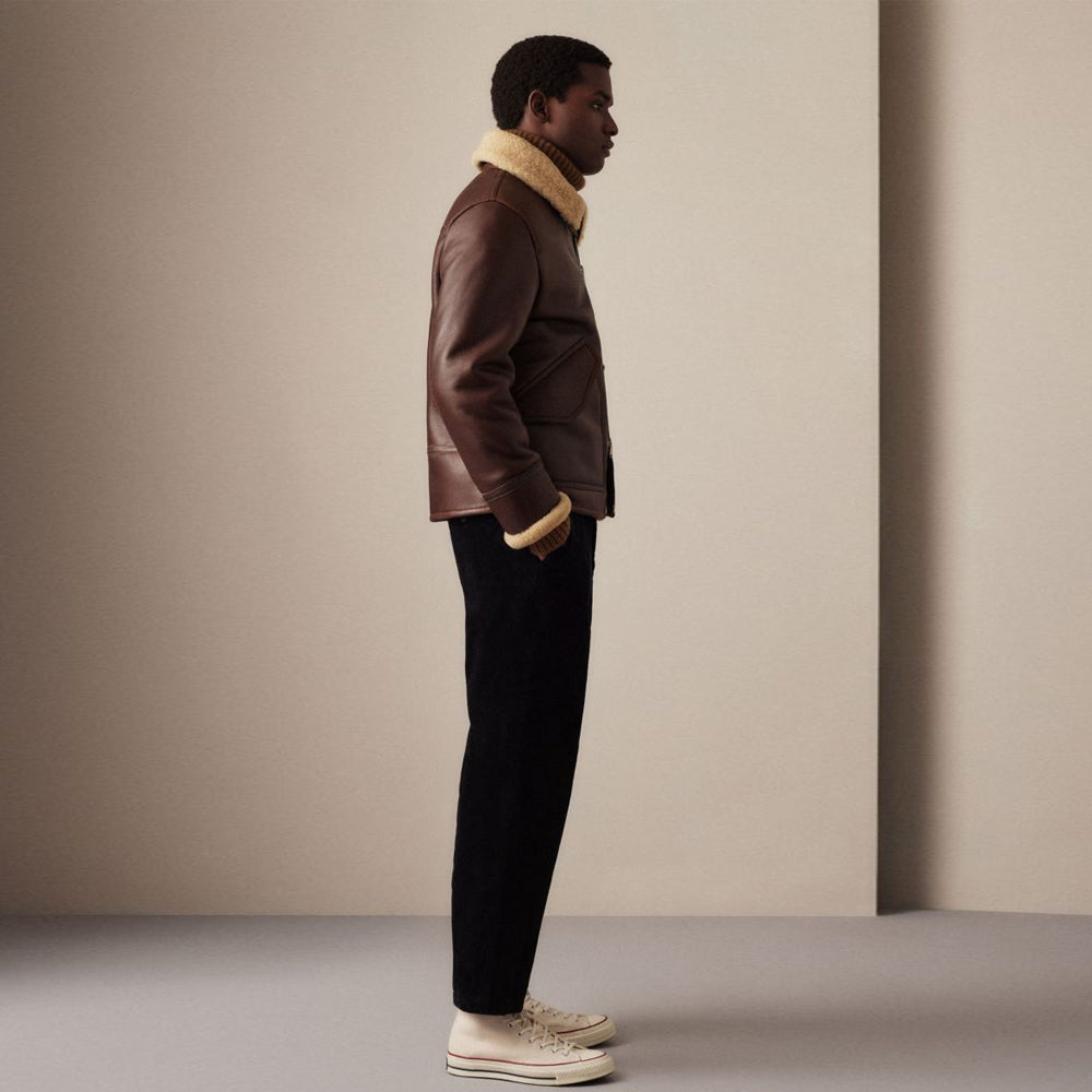 Side view of men's espresso brown shearling bomber jacket showing clean hem line and exposed wool cuffs