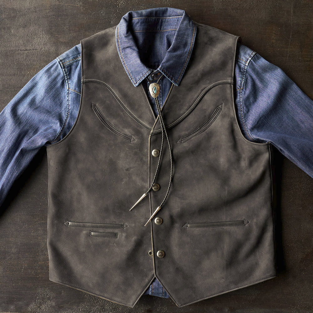 Southwestern snap-front cowboy vest layered with a blue denim shirt and decorative turquoise bolo accessory