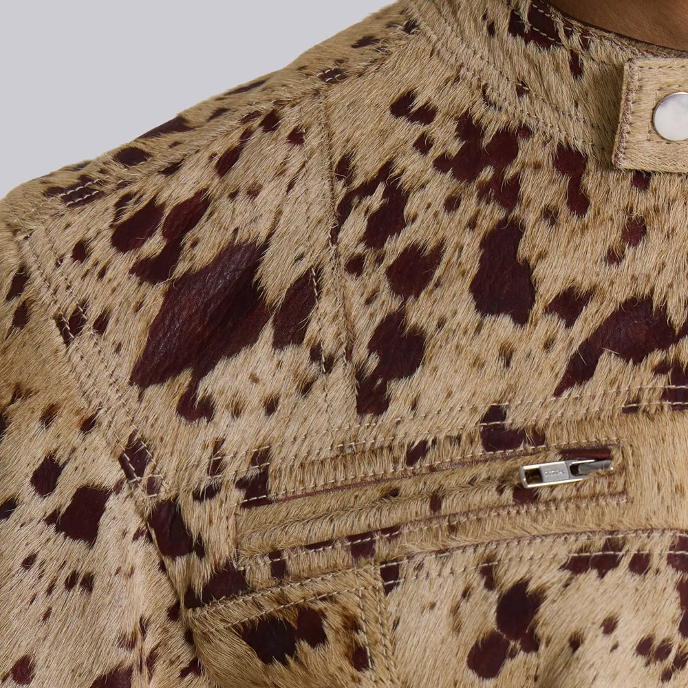Detail of YKK zip chest pocket and shoulder seams on a tan speckled cowhide jacket