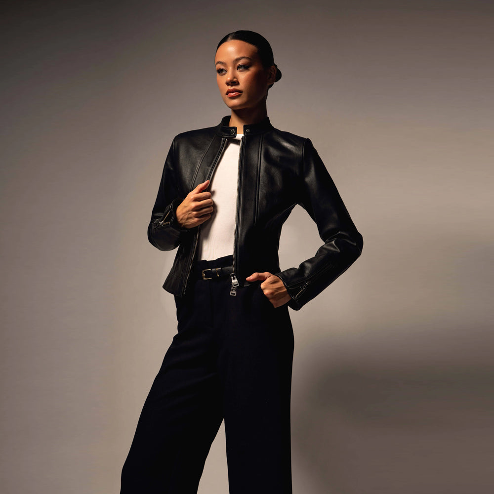 Women’s tailored leather racer jacket worn open over a white top with black trousers
