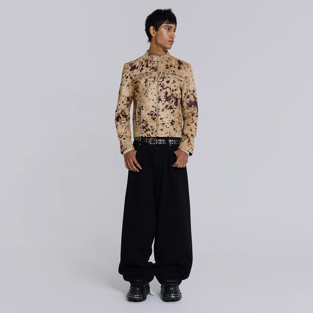 Full-length styling view of a tan cowhide moto jacket with cropped slim fit and brown spots