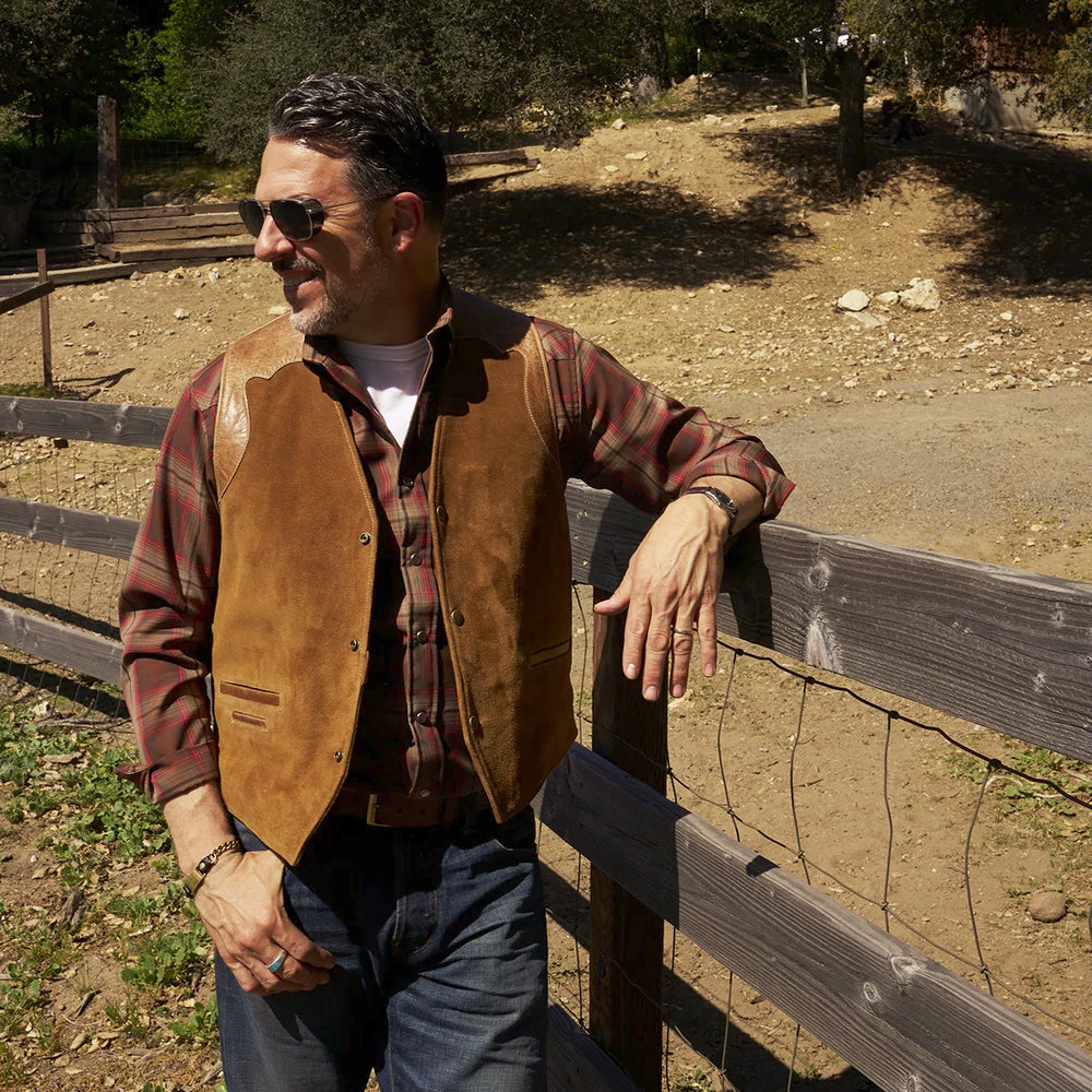 Three-quarter lifestyle view showing the regular fit and deep V-neck profile of the men’s tan suede leather waistcoat