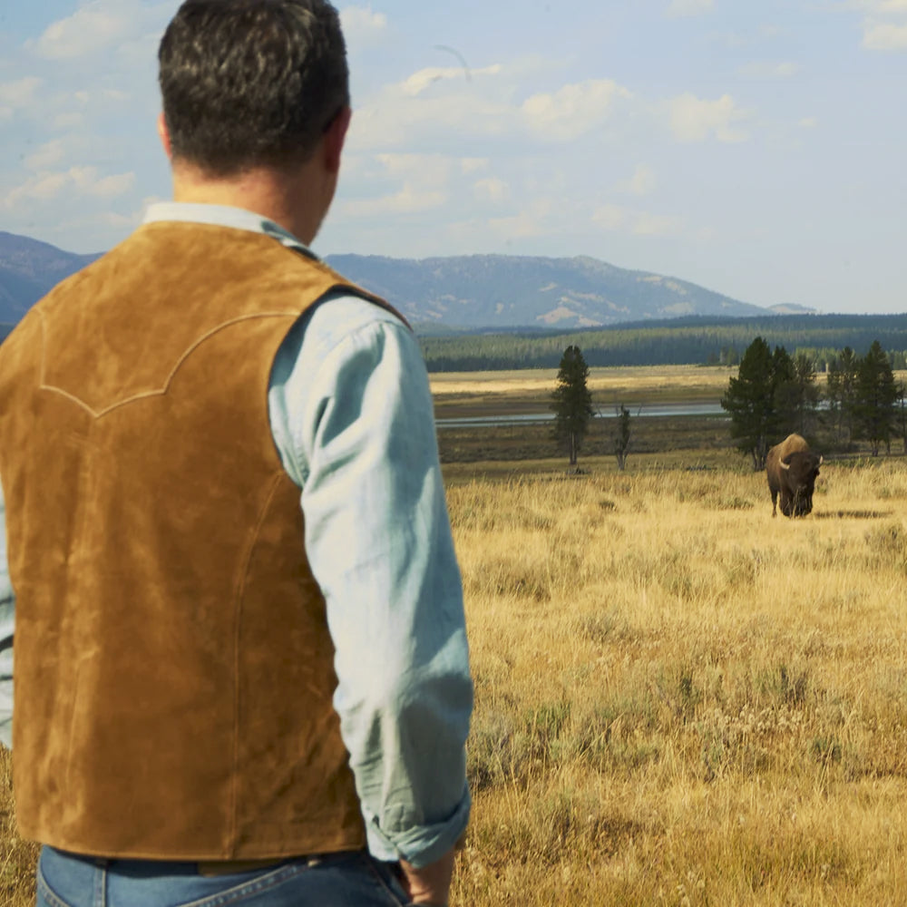 Outdoor rear view of a man wearing the tan suede Western vest with its clean pointed yoke visible