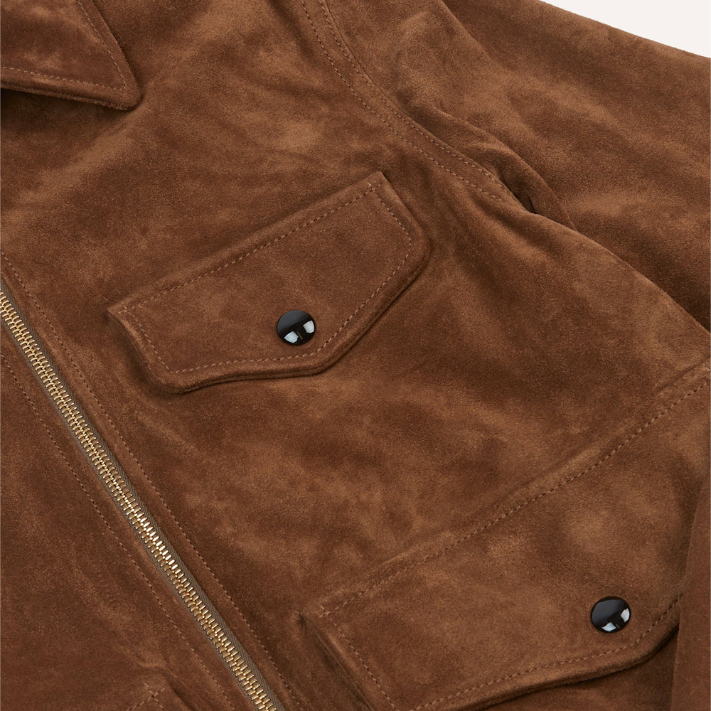 Detailed view of tobacco calfskin suede chest and lower flap pockets finished with rounded black enamel snaps.