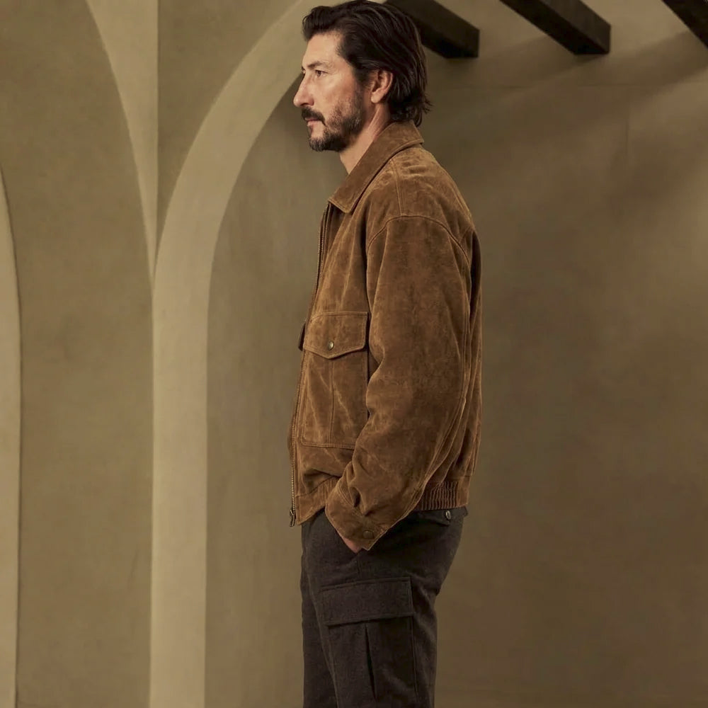 Side-rear view of tobacco suede jacket displaying the adjustable sleeve cuff and gathered rib-knit section along the back hem.