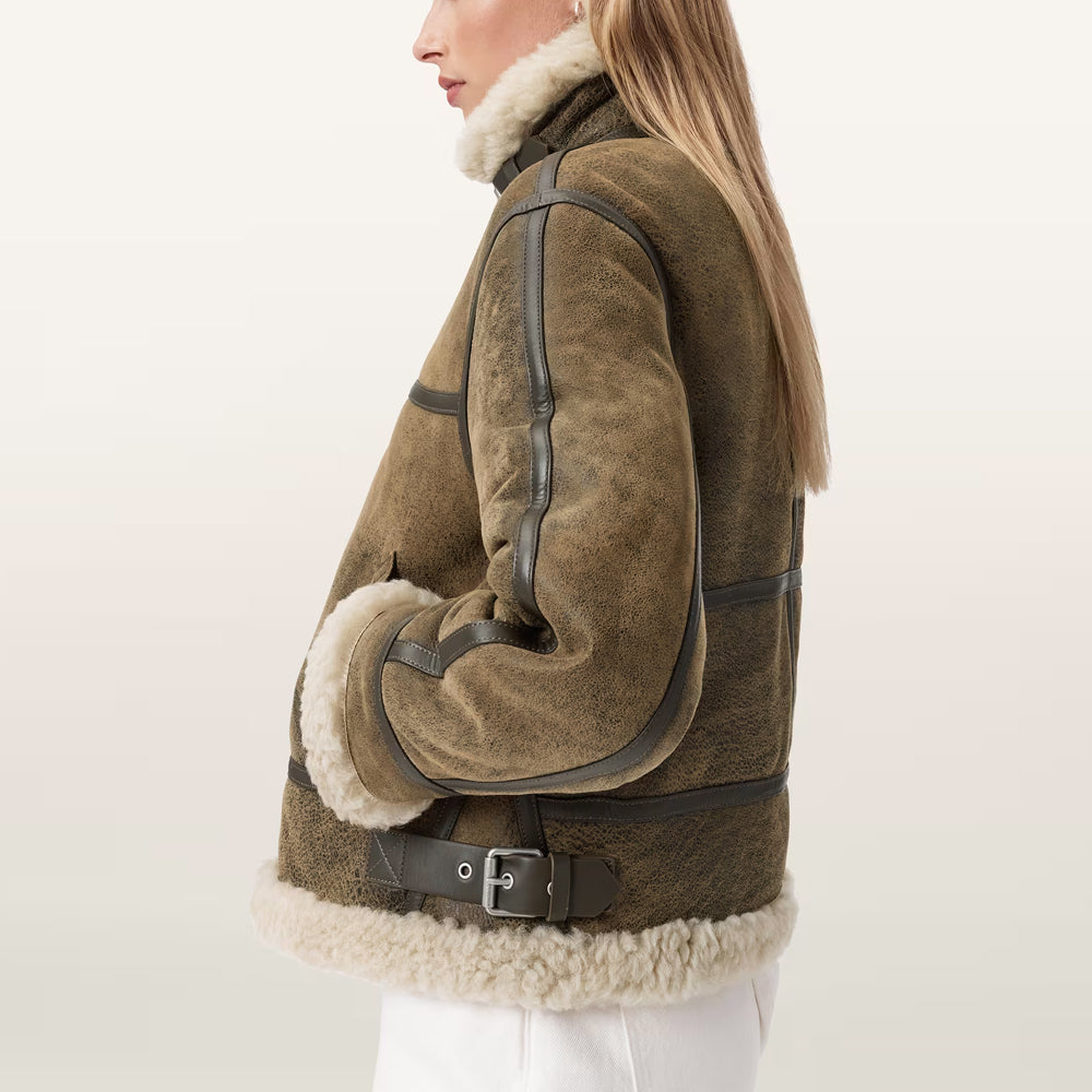 Side profile of ladies' distressed olive B-3 flight coat highlighting dark brown leather welt piping and waist buckle strap.