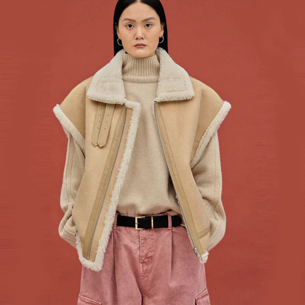 Woman wearing a beige nubuck sheepskin aviator vest with oversized fur collar, front view