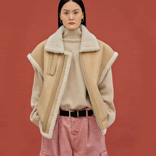 Woman wearing a beige nubuck sheepskin aviator vest with oversized fur collar, front view