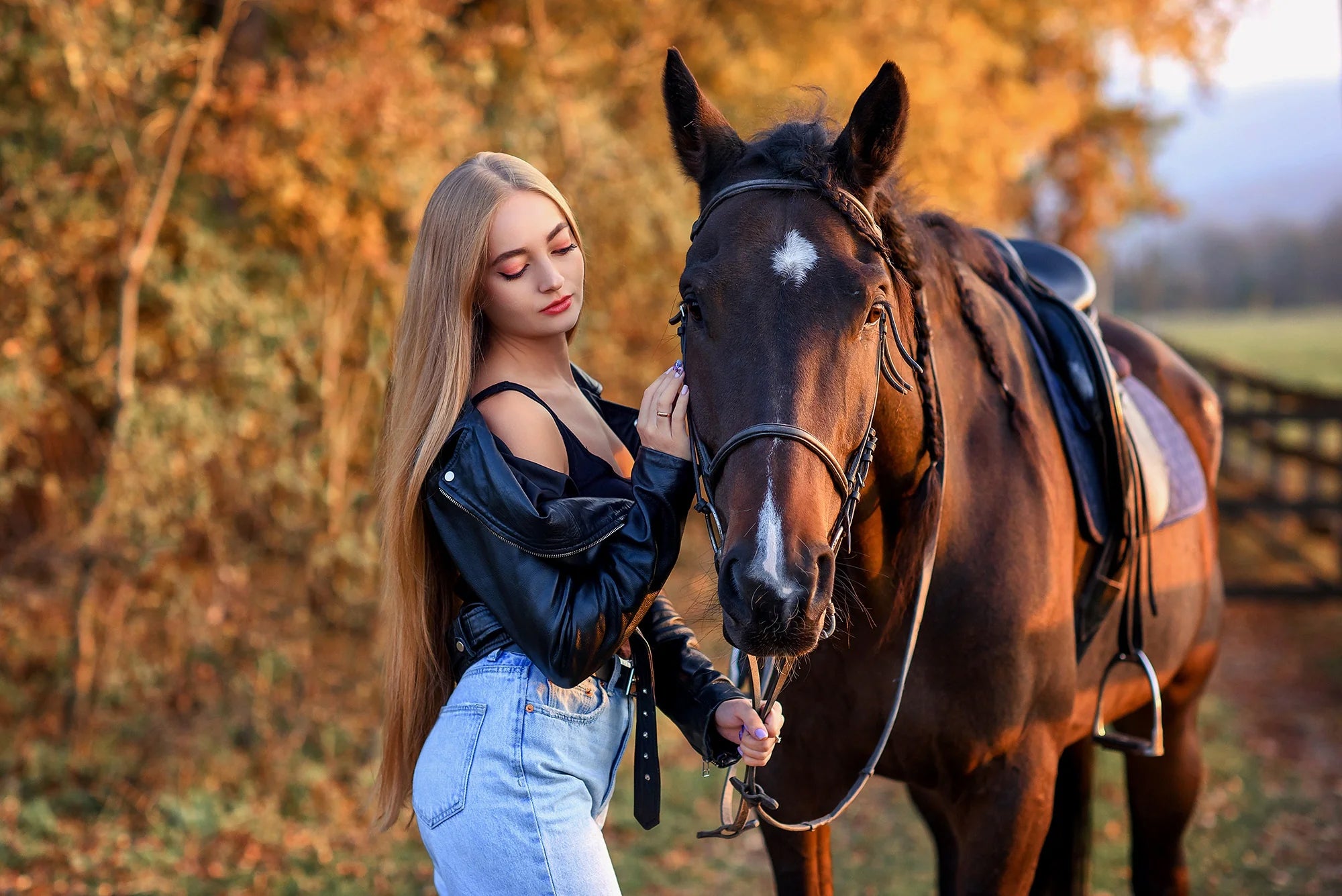 Woman wearing black leather jacket standing with horse in autumn outdoor setting - Sheepskin Leathers