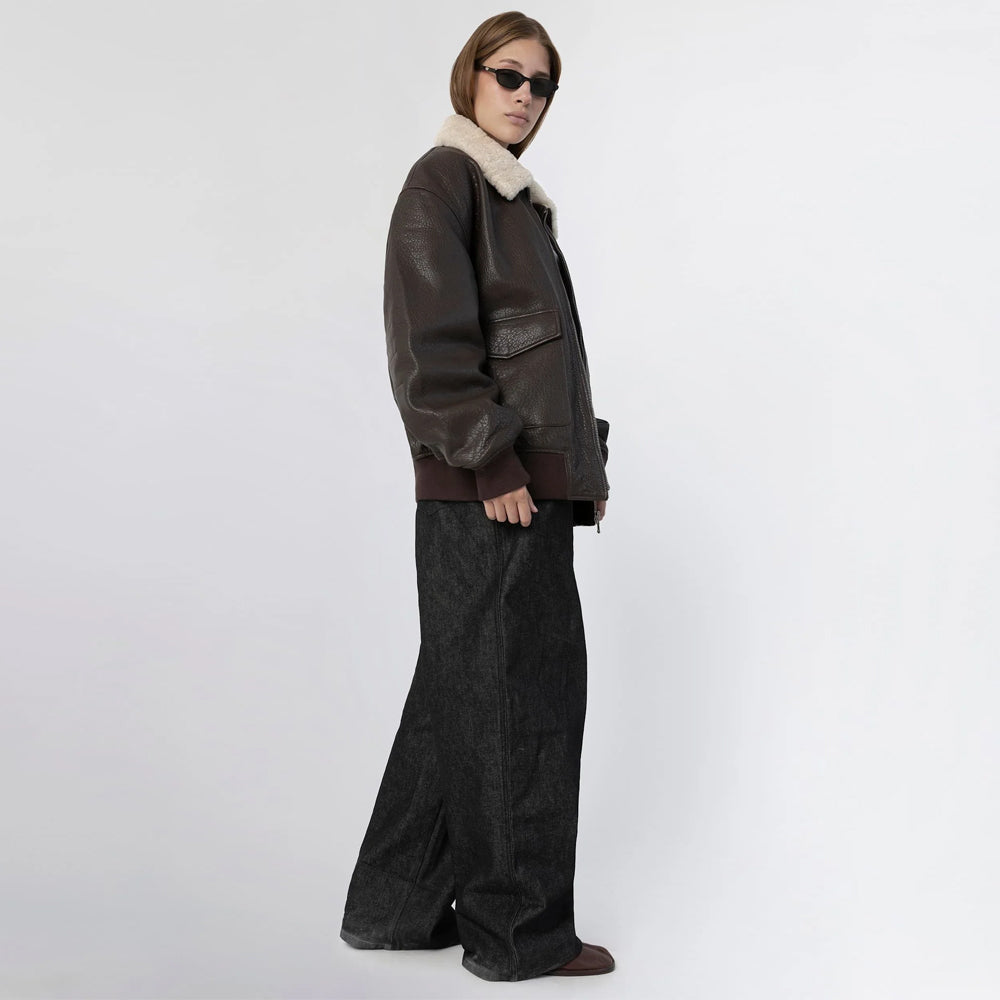 Side view of women's oversized brown leather bomber jacket showing the large flap pocket and shearling collar
