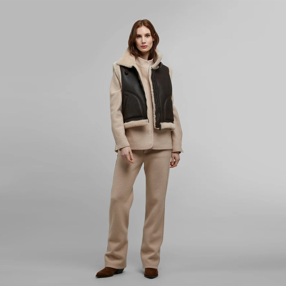 Full outfit view of women’s chocolate shearling gilet layered over neutral winter knitwear