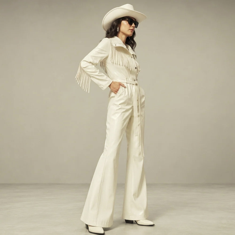 Side view of a white cowgirl leather jumpsuit with sleeve fringe, a tied waist, side pocket and widening trouser hems.