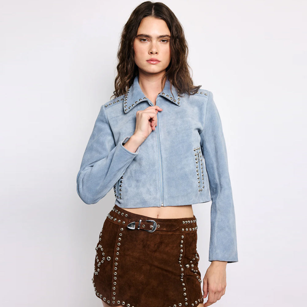 Front view of a female model wearing the exclusive cashmere blue suede cropped studded jacket.